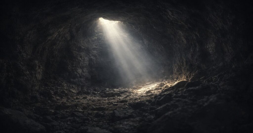 magen simbólica de una cueva iluminada por un rayo de luz, que representa confiar en Dios en medio de la angustia y la sensación de estar rodeado.