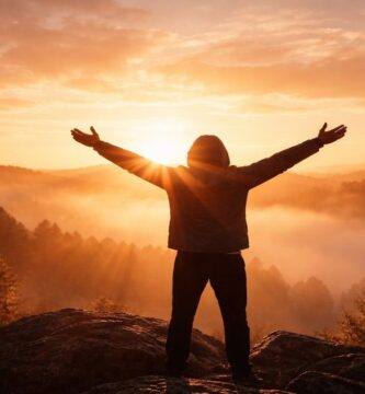 Imagen simbólica de una persona sosteniendo los brazos en alto al amanecer, representando la fe que permanece aun en medio del cansancio.