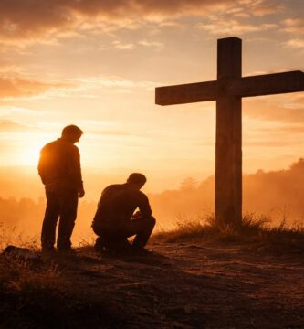 Dos siluetas humanas frente a una cruz al amanecer, símbolo de la misericordia de Dios ofrecida a todos, incluso en medio del dolor.