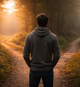 Persona de espaldas detenida frente a dos caminos al amanecer, símbolo de la decisión y el dominio propio en la vida cristiana.