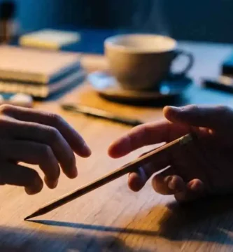 Manos soltando un lápiz sobre un escritorio, reflexión sobre por qué me cuesta confiar en Dios y soltar el control.
